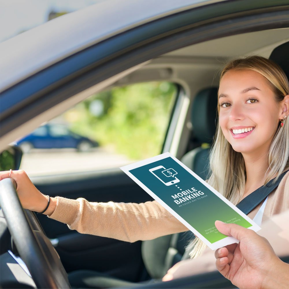Drive up envelope shown in use with bank teller and banking customer