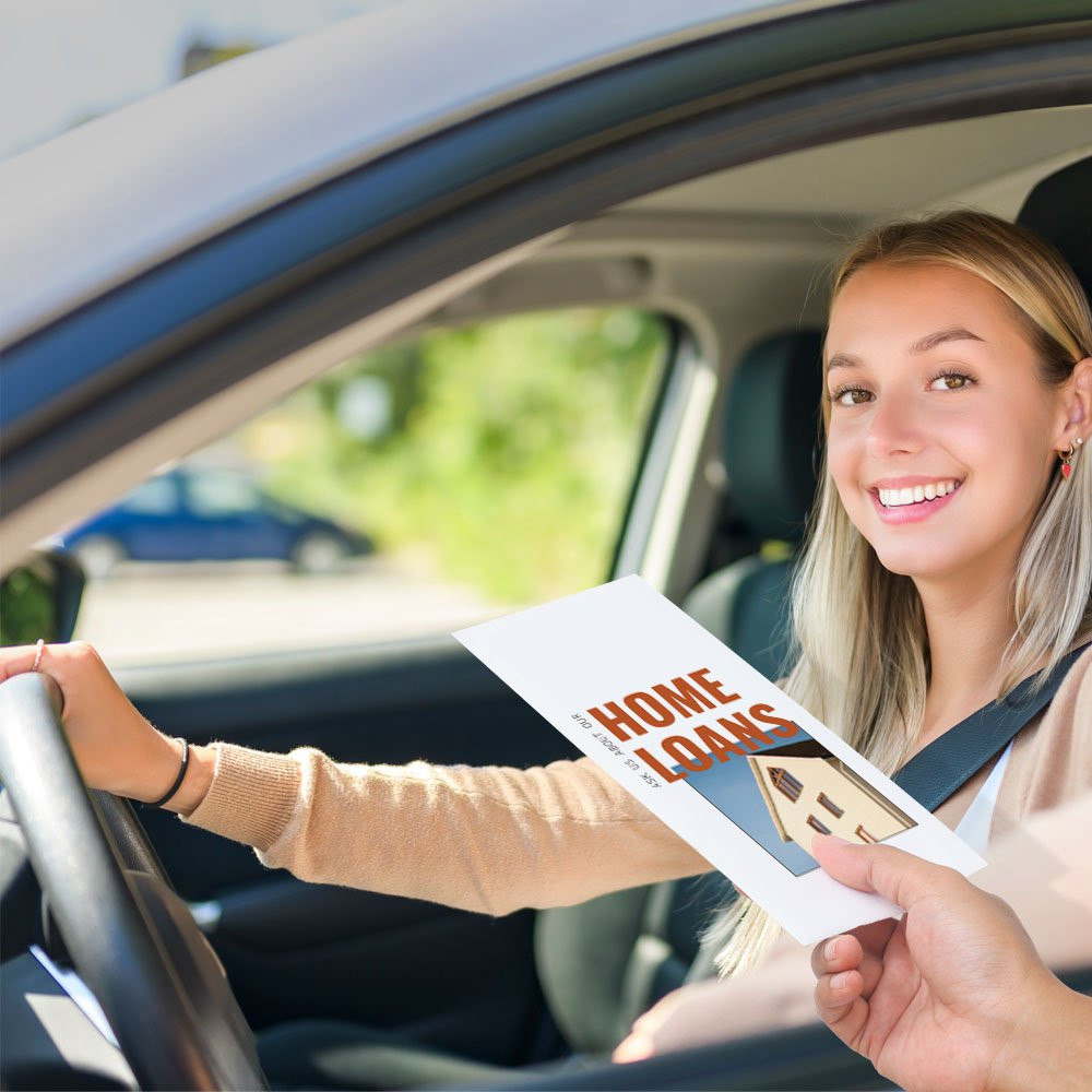 Bank customer at teller window receiving drive up money envelope 