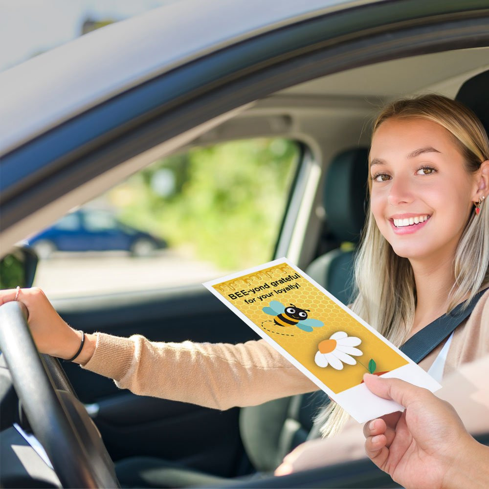 Bank customer at teller window receiving drive up money envelope 