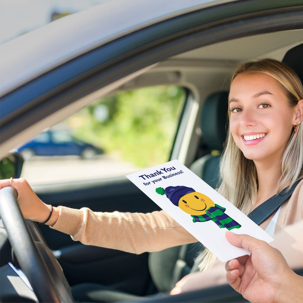 Bank customer at teller window receiving drive up money envelope 