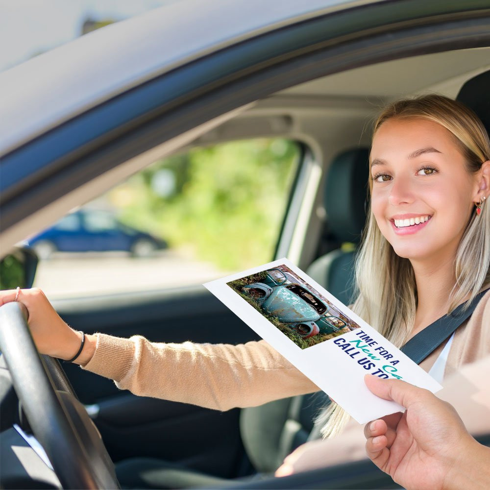 Bank customer at teller window receiving drive up envelopes for cash