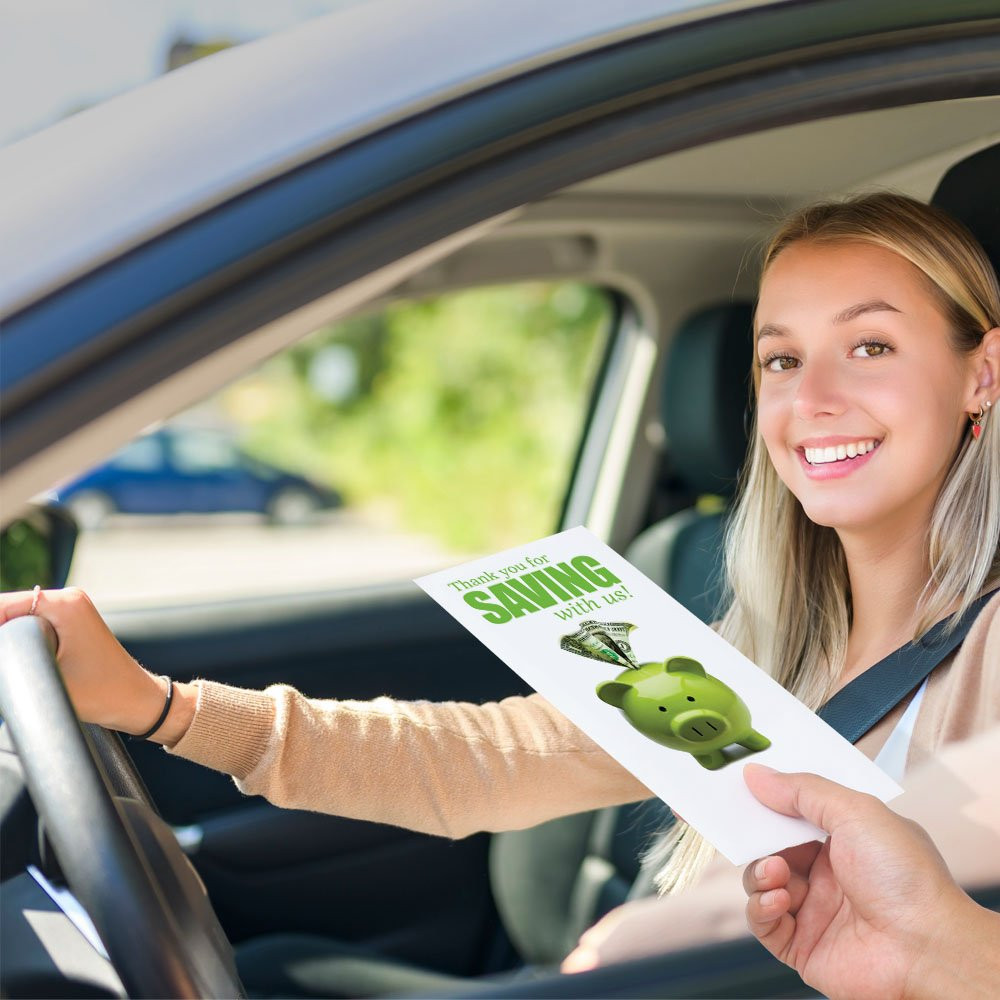 Bank customer at teller window receiving drive up envelopes for cash