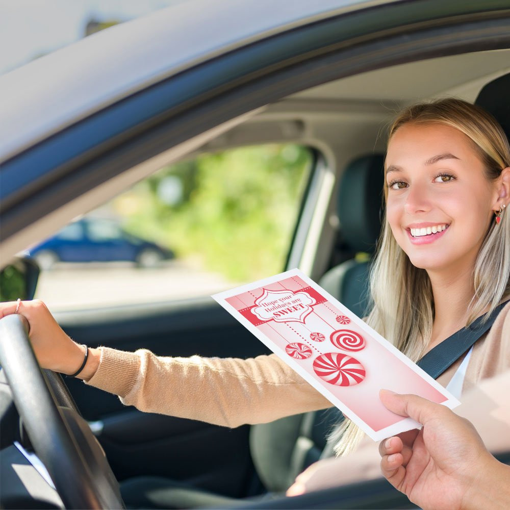Bank customer at teller window receiving drive up money envelope 