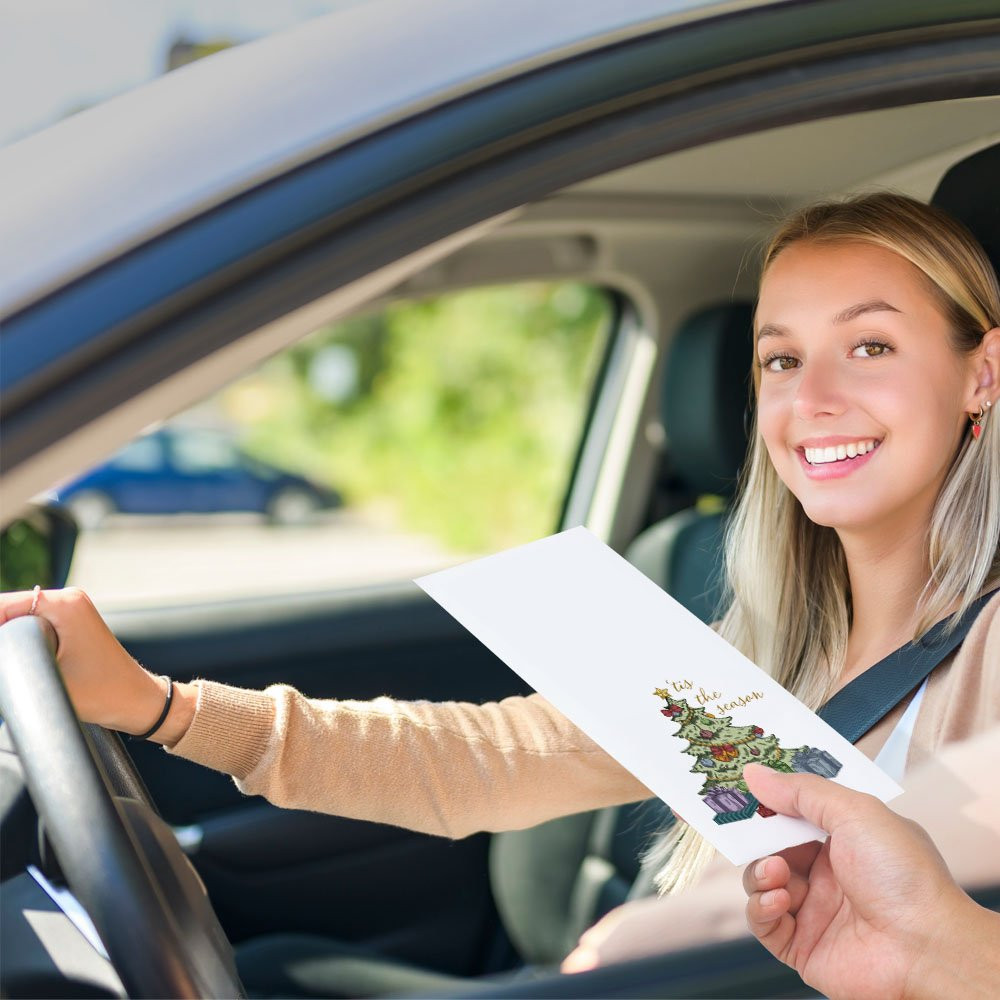 Bank customer at teller window receiving drive up money envelope 