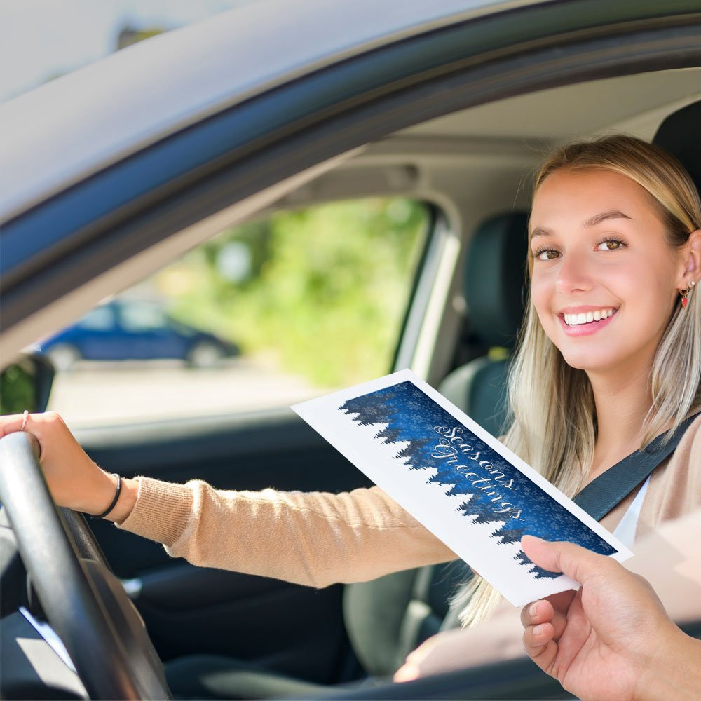 Bank customer at teller window receiving drive up money envelope 