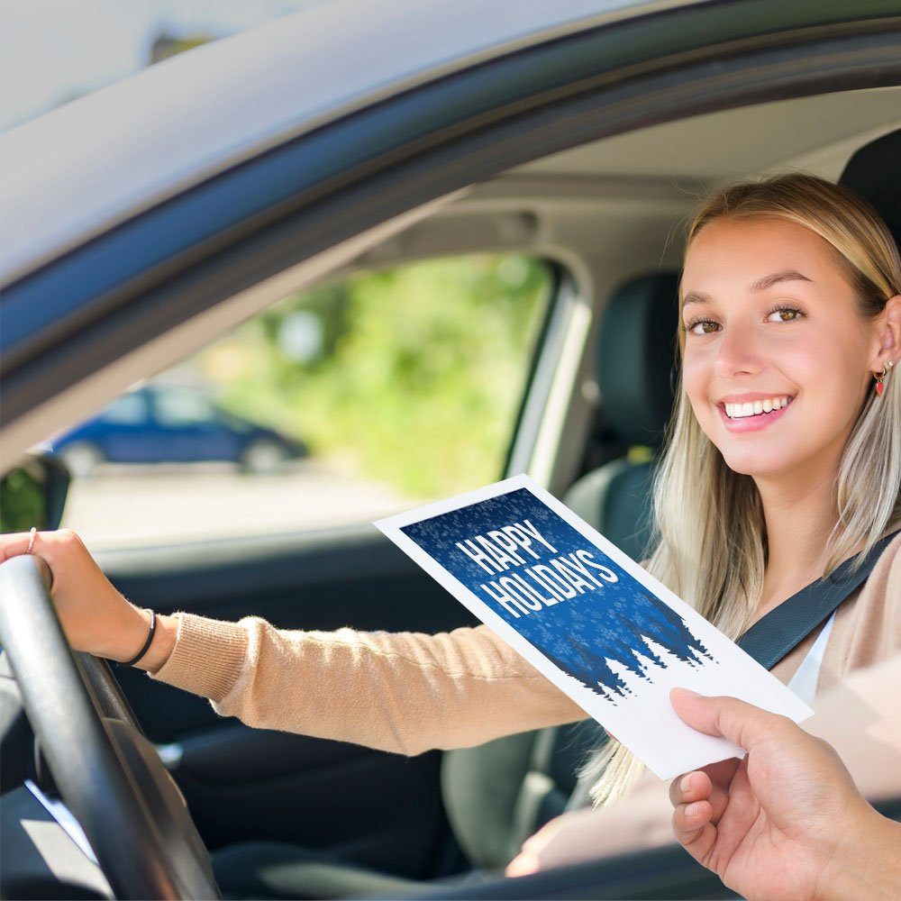 Bank customer at teller window receiving drive up envelopes for cash