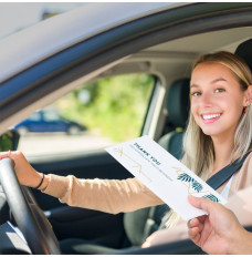 Bank customer at teller window receiving drive up money envelope 