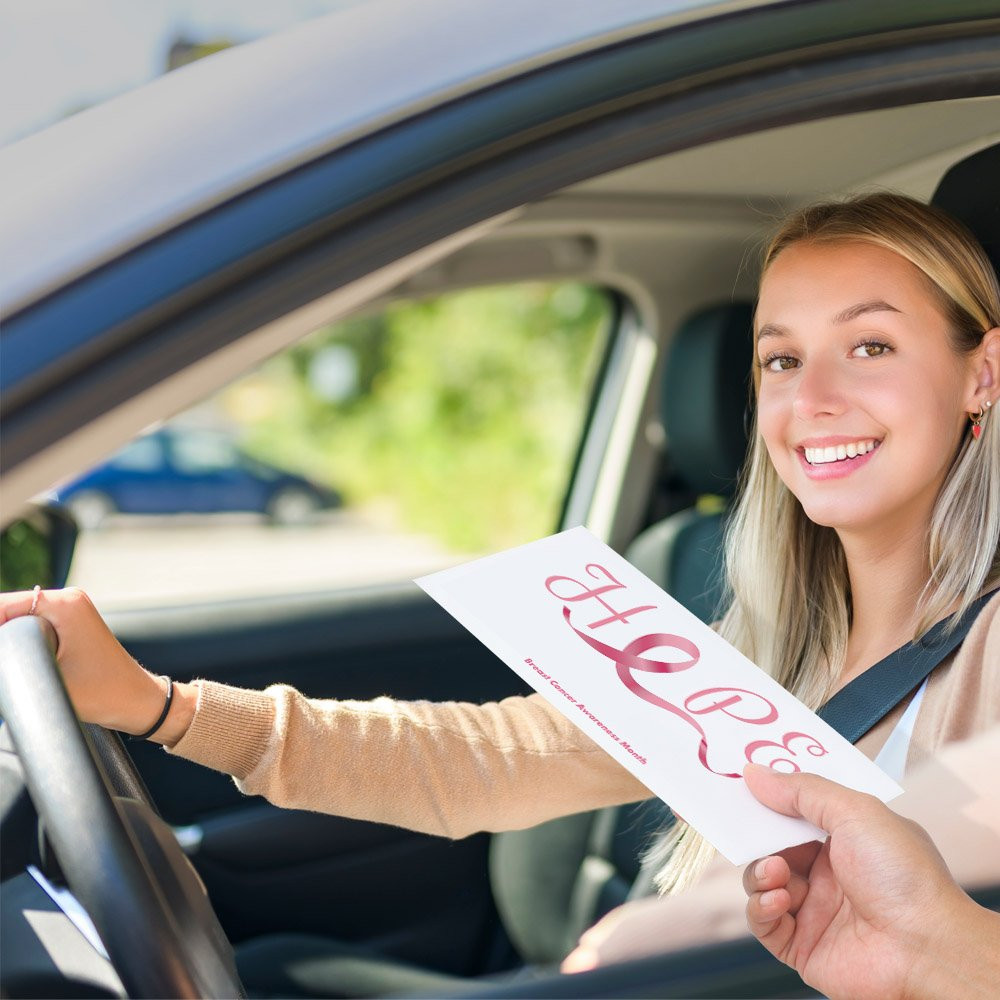 Bank customer at teller window receiving drive up envelopes for cash