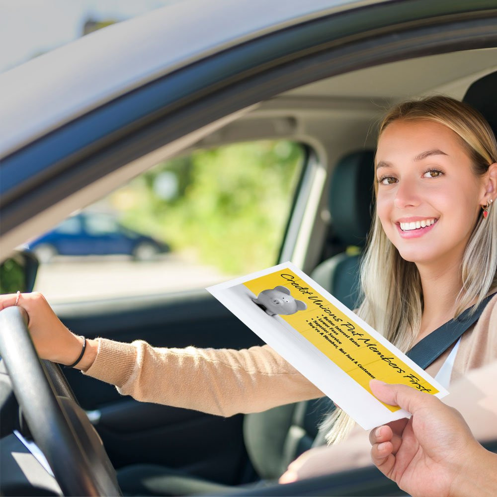 Bank customer at teller window receiving drive up envelopes for cash