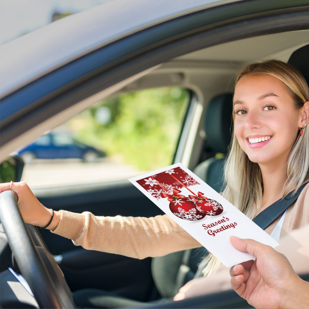 Bank customer at teller window receiving drive up envelopes for cash