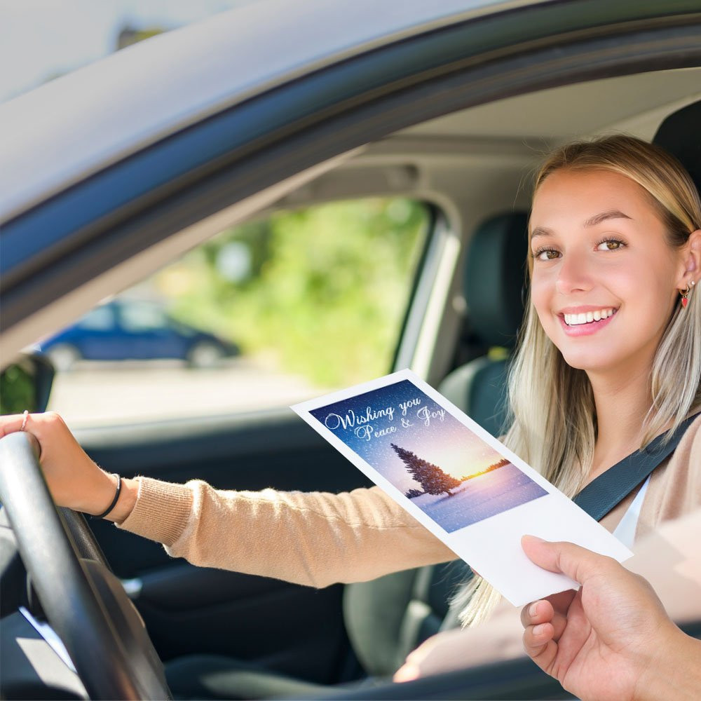 Bank customer at teller window receiving drive up money envelope 